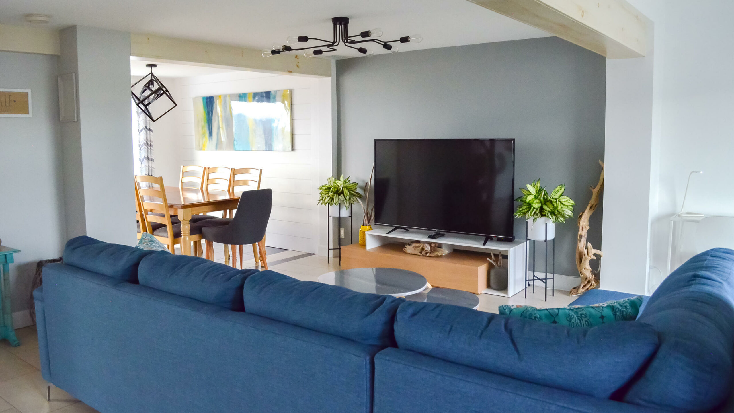 Vue sur le salon avec sofa d’angle et TV et la salle à manger du chalet Les Grandes Marées au Logis du Bois Flotté