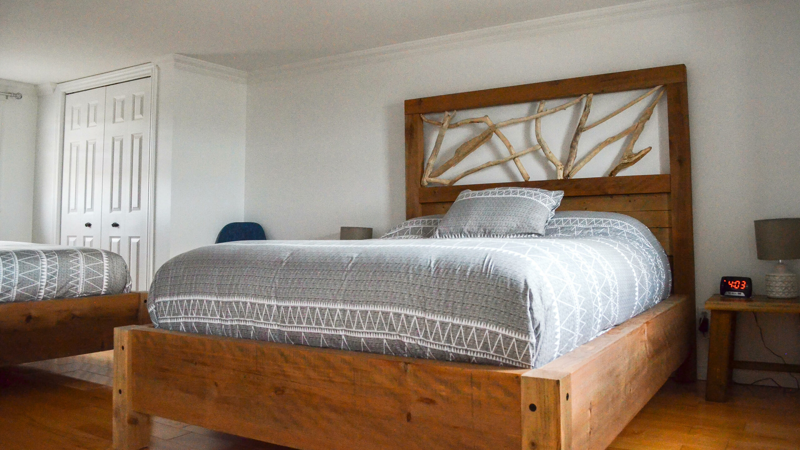 Chambre moderne avec lit en bois et décoration de style bord de mer d’un chalet du Logis du Bois Flotté
