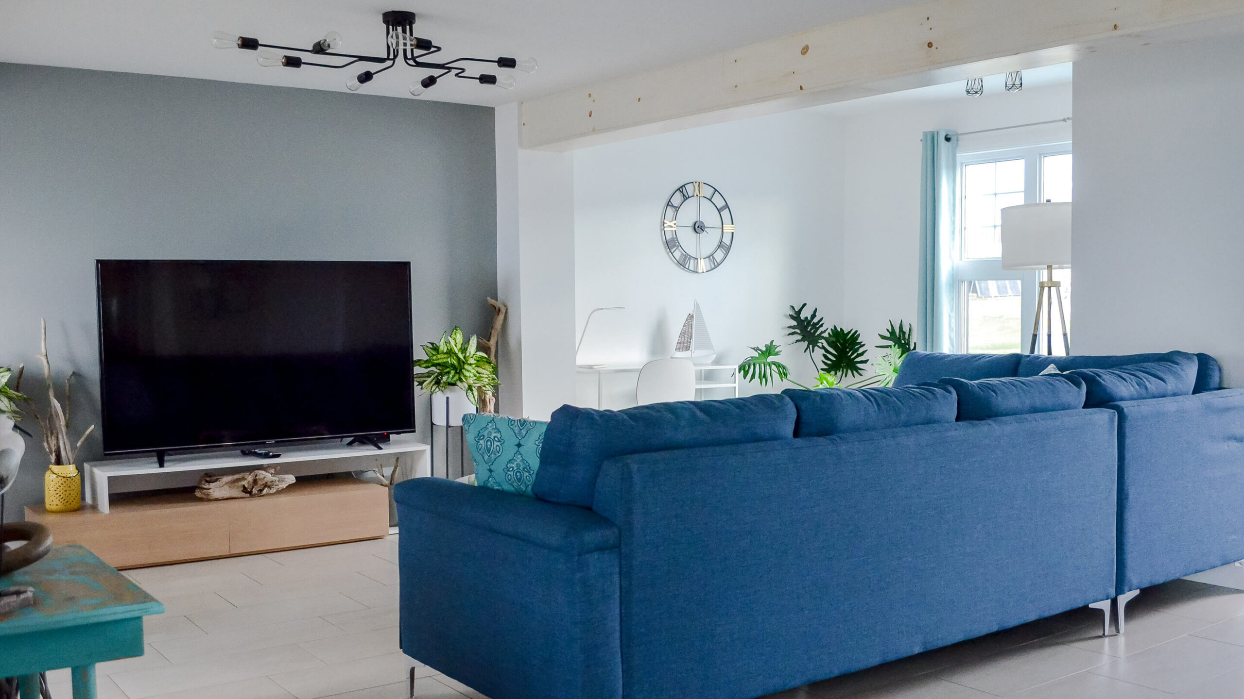 Salon à la décoration moderne avec un confortable sofa et télévision d’un chalet du Logis du Bois flotté