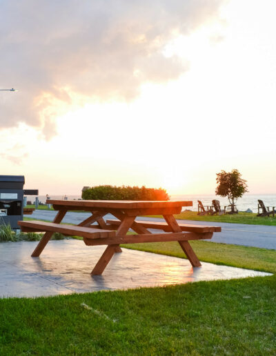 Vue sur une table de pique-nique devant un chalet du Logis du Bois Flotté avec vue sur le fleuve
