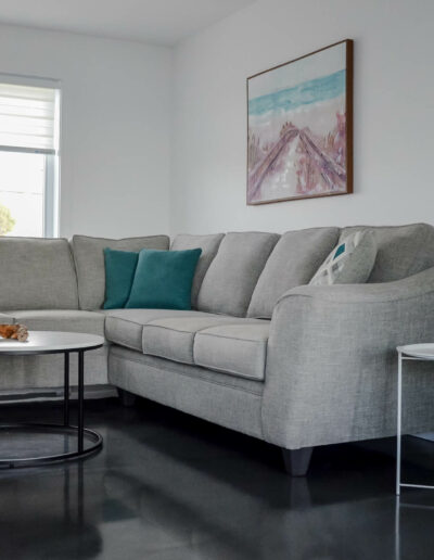 Salon à la décoration moderne avec un confortable sofa gris du chalet Le Fleuve tranquille au Logis du Bois Flotté