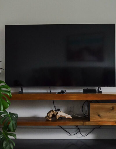 Meuble avec TV en bois et décoration personnalisée de style bord de mer du chalet Le Fleuve tranquille au Logis du Bois Flotté