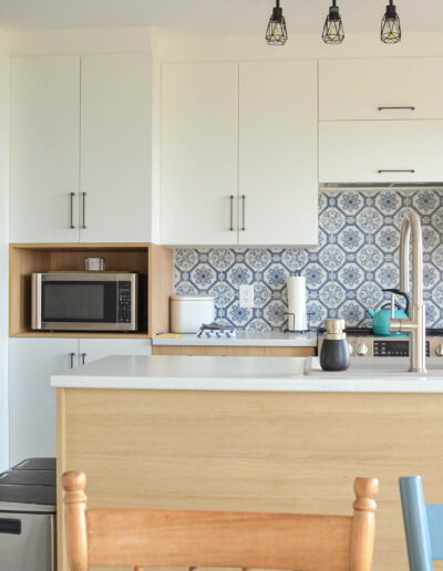 Cuisine moderne avec électroménagers en stainless et dosseret en carrelage bleu du chalet Le Fleuve tranquille au Logis du Bois Flotté