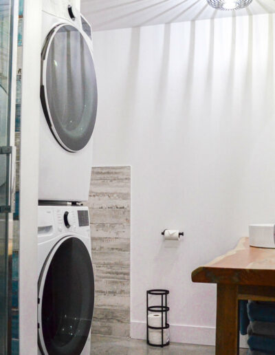 Espace lavage avec machine à laver et sèche-linge dans la salle de bain du chalet Le Fleuve tranquille au Logis du Bois Flotté