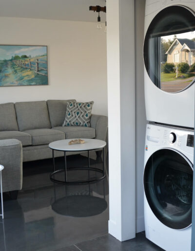 Salon moderne avec un confortable sofa et espace de lavage du chalet L’Écume des vagues au Logis du Bois Flotté