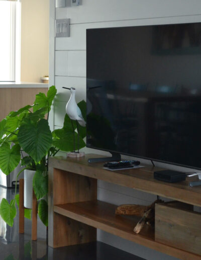 Meuble avec TV en bois et décoration personnalisée de style bord de mer du chalet L’Écume des vagues au Logis du Bois Flotté