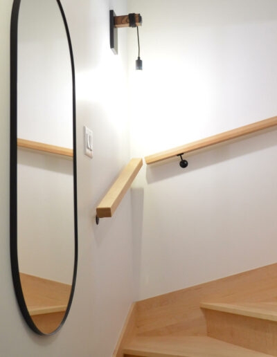 Cage d’escalier avec grand miroir oval du chalet L’Écume des vagues au Logis du Bois Flotté