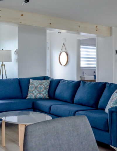 Salon à la décoration moderne avec sofa bleu en angle et table basse du chalet Les Grandes Marées au Logis du Bois Flotté