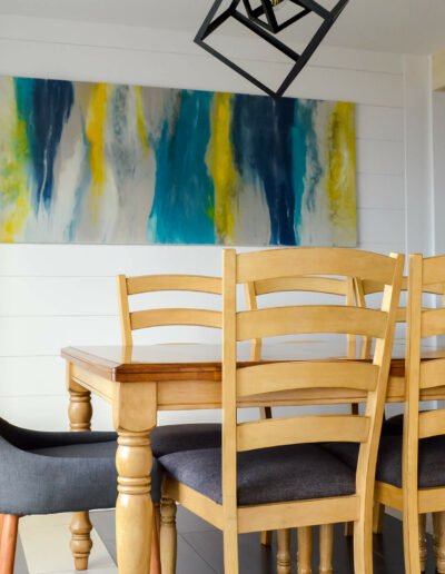Salle à manger avec table et chaises en bois, à la décoration moderne de style bord de mer du chalet Les Grandes Marées au Logis du Bois Flotté
