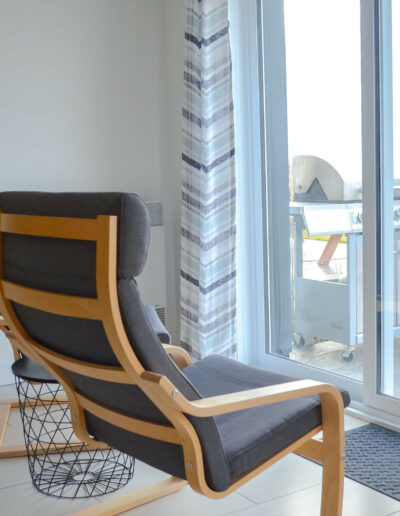 Deux fauteuils pour relaxer devant la baie vitrée de la cuisine avec vue sur le fleuve du chalet Les Grandes Marées au Logis du Bois Flotté